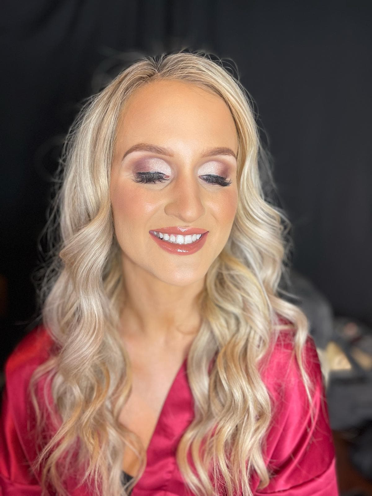 Client with soft glam makeup and long curled blonde hair